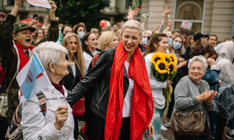 Maryja Kalesnikava hymyilee kadulla väkijoukon keskellä.